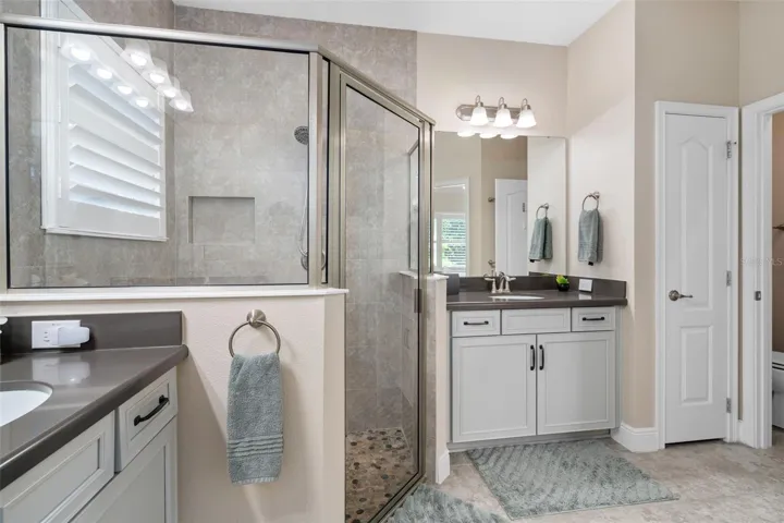 The Primary En-Suite Shower offers Upgraded Wall and Floor Tile. There is also a Linen closet and Water Closet.