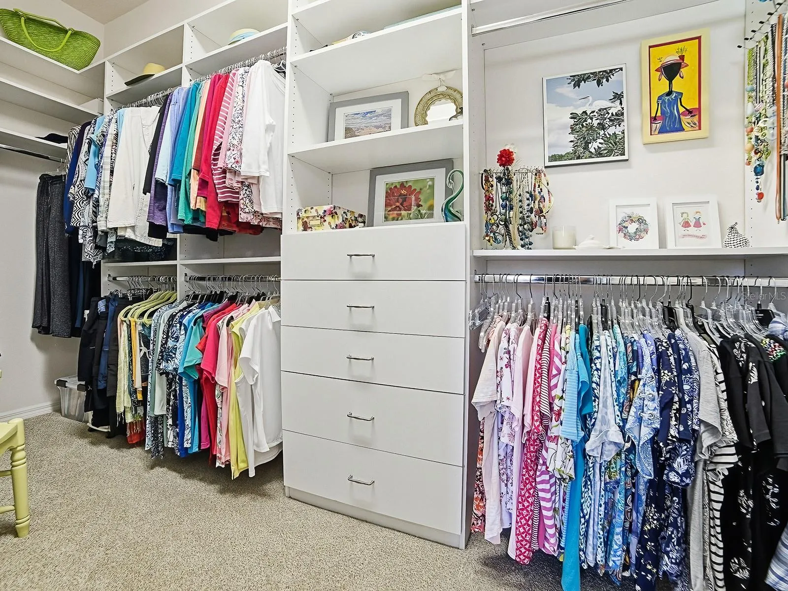 Owners walk in closet with built in dresser and shelves