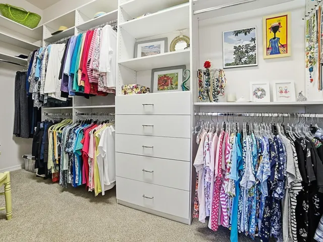 Owners walk in closet with built in dresser and shelves