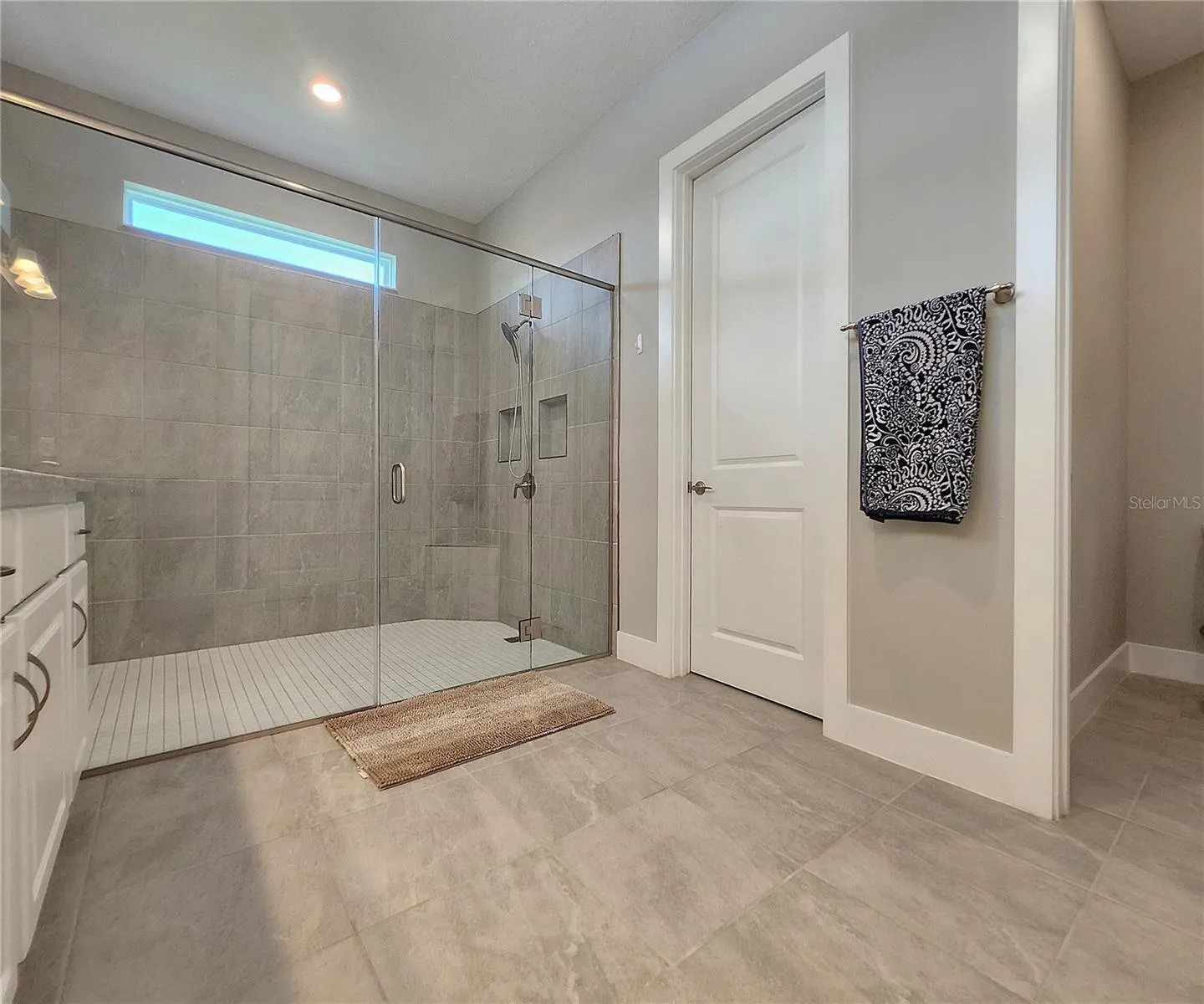 Master bathroom includes large walk-in  tiled shower, water closet, walk-in closet, dual sink vanity, granite countertops