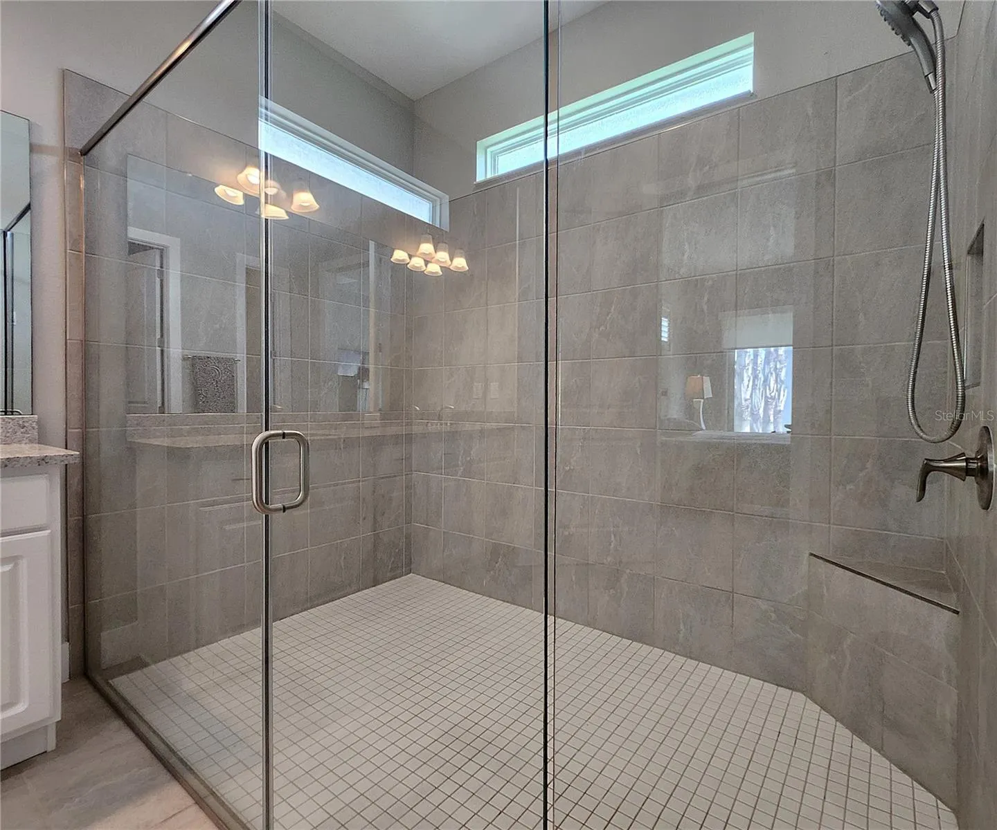Master bathroom includes large walk-in  tiled shower, water closet, walk-in closet, dual sink vanity, granite countertops