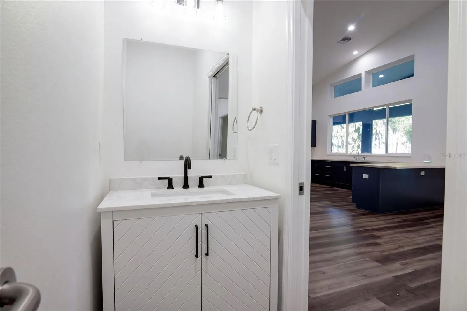 Guest half bath with chevron vanity and matte black fixtures