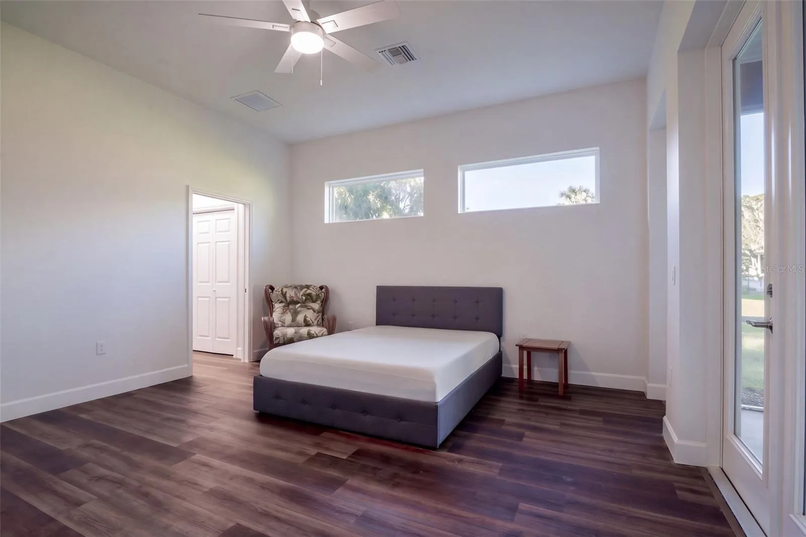 Primary suite with clerestory windows, ceiling fan, and two closets, including a walk-in