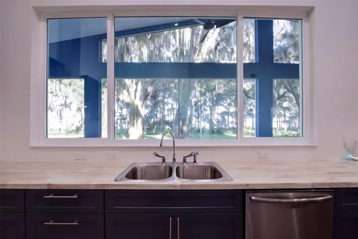 Oversized triple window over the sink with views to the lake