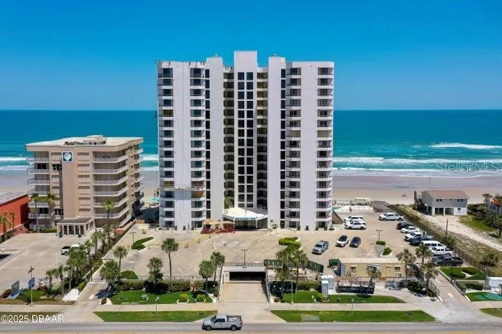 The building's clean façade and gated entrance welcome residents with manicured landscaping, ample parking, and ocean views from every level.