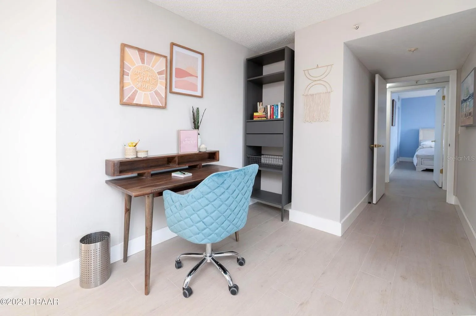 A convenient workspace within the primary suite offers room for a desk and shelving, providing a functional area for remote work, reading, or organizing daily essentials.