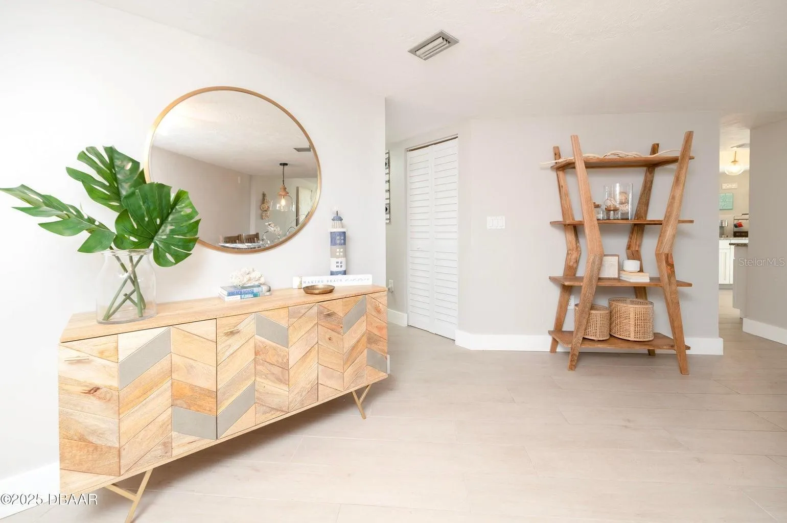 This bright, coastal-inspired entry features neutral tones, creating an inviting introduction to the residence.
