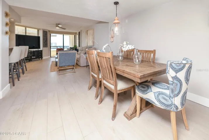 Enjoy an open, connected floor plan that brings together the dining room, kitchen, and living area. Neutral finishes and a direct view toward the oceanfront balcony enhance the relaxed coastal atmosphere.