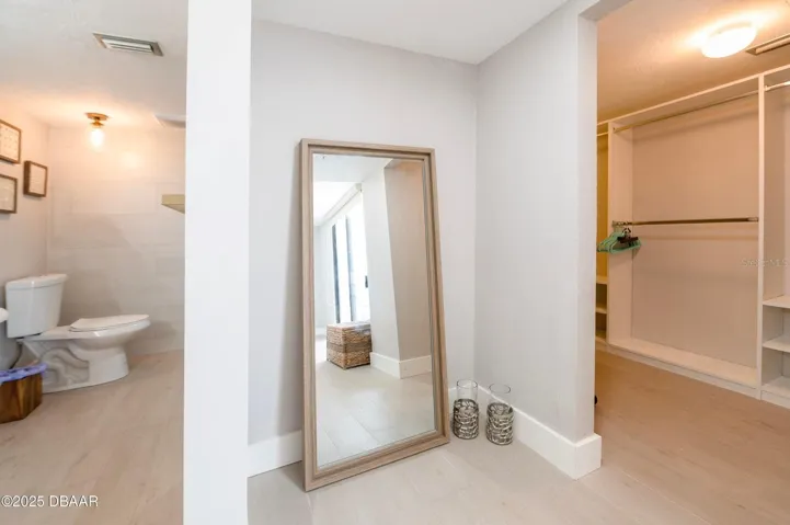 Enjoy a dedicated dressing area with an open closet featuring hanging space and built-in shelving, conveniently positioned near the primary bathroom.