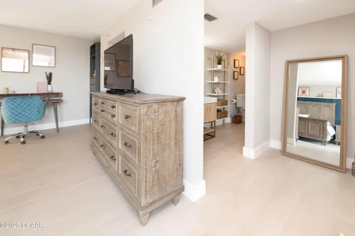 The primary suite offers a spacious dressing area with room for additional furnishings and convenient access to the adjoining bathroom.