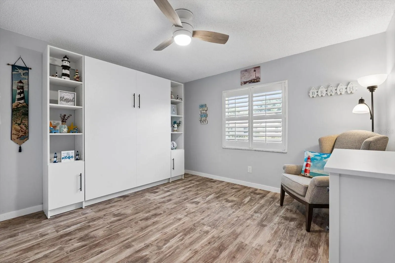 Second bedroom with murphy bed (conveys with home).  Plantation shutters and large closet.