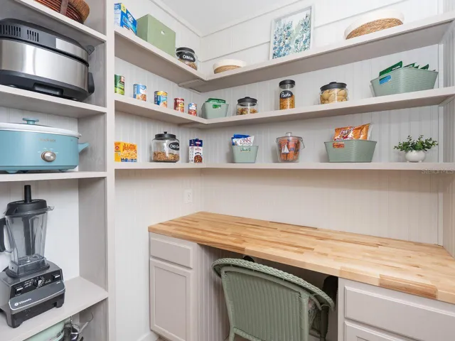 walk in pantry and small appliance closet with built in desk
