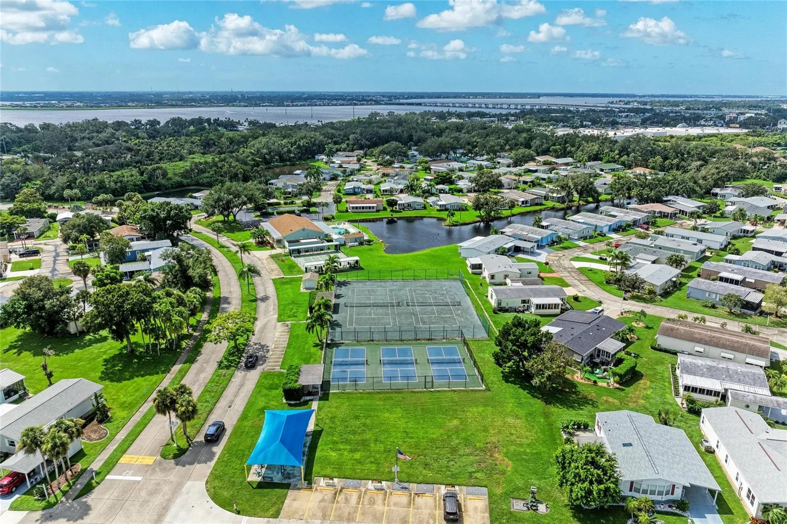 View of tennis and pickelball courts. Under the blue cover is the small fitness "gym"
