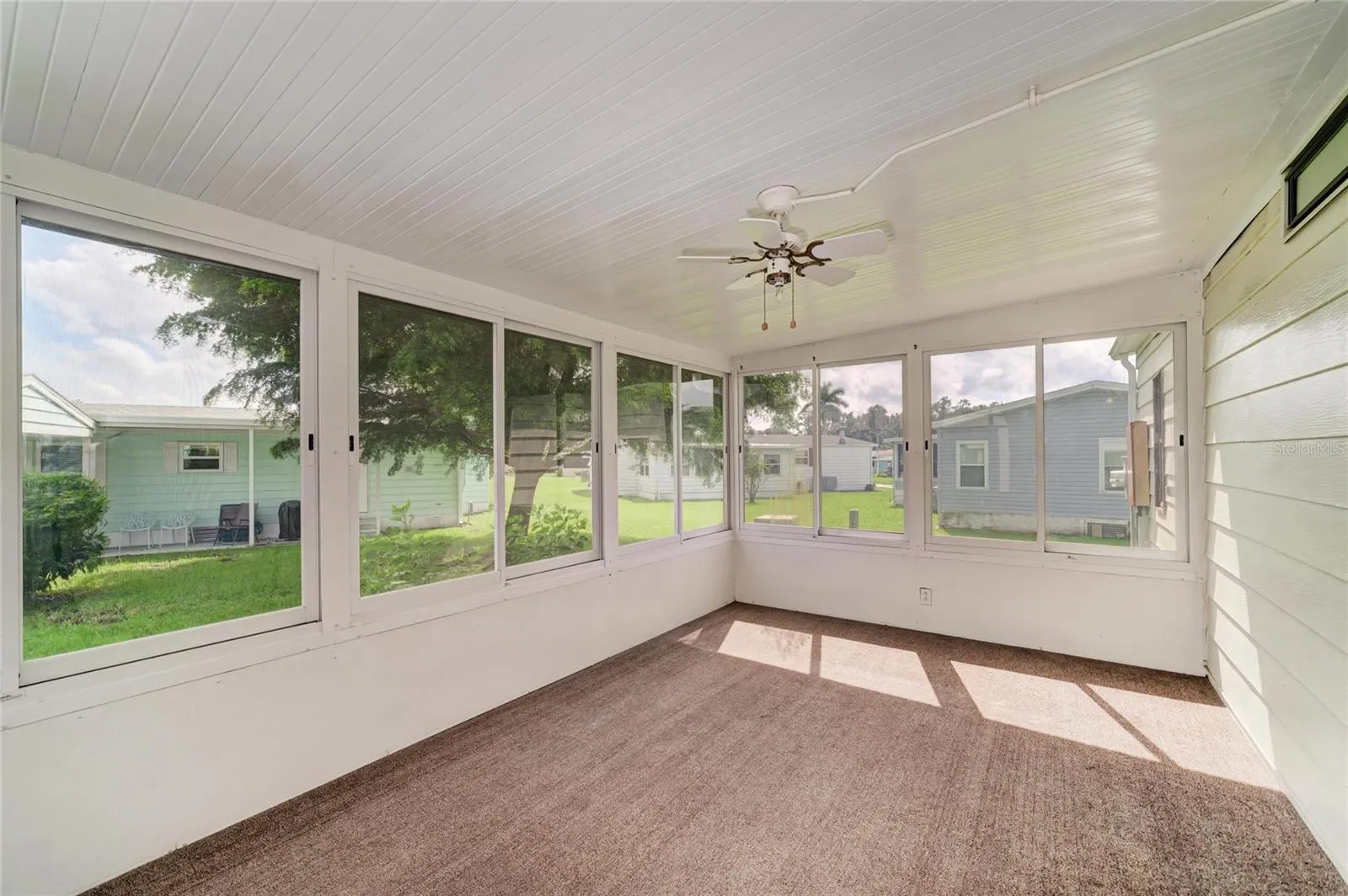 Nice and spacious sun room. Just add some pull down shades for added privacy. These are hard plastic windows, Good opportunity to add a mini-split for year round enjoyment. Sunroom accessible from laundry roof with additional door to carport.