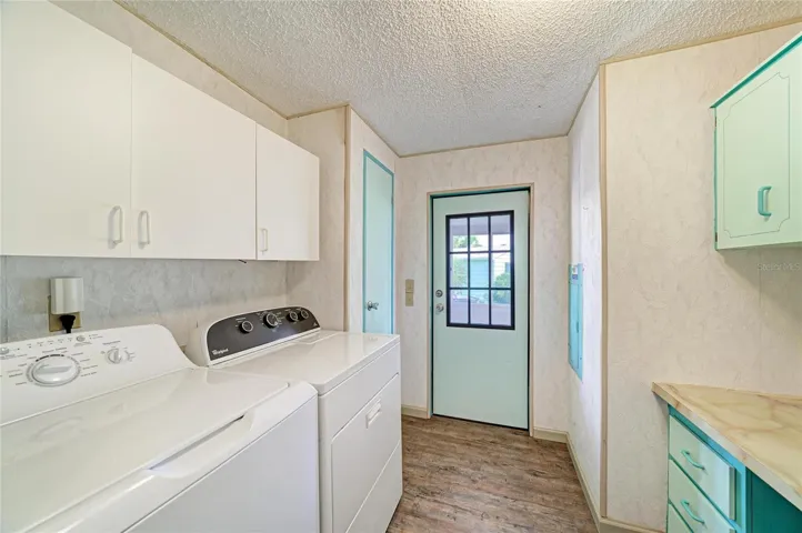 Inside laundrywith plenty of cabinets for storage and a good size countertop for folding or built in desk