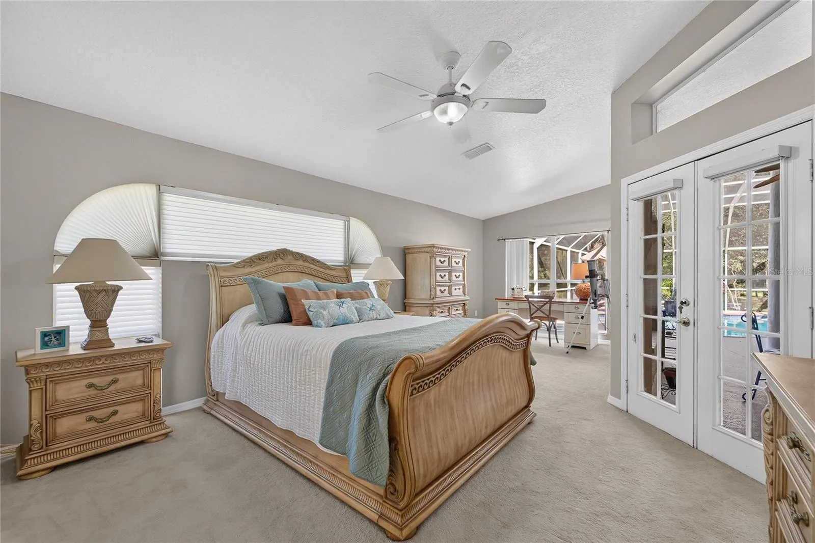 Primary bedroom has French doors to the pool