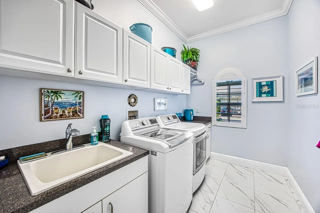 Laundry room with utility sink and storage cabinets