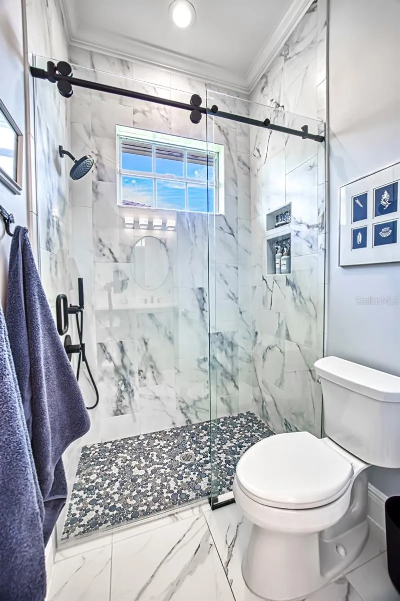 Shower with barn door glass doors - tiled walls