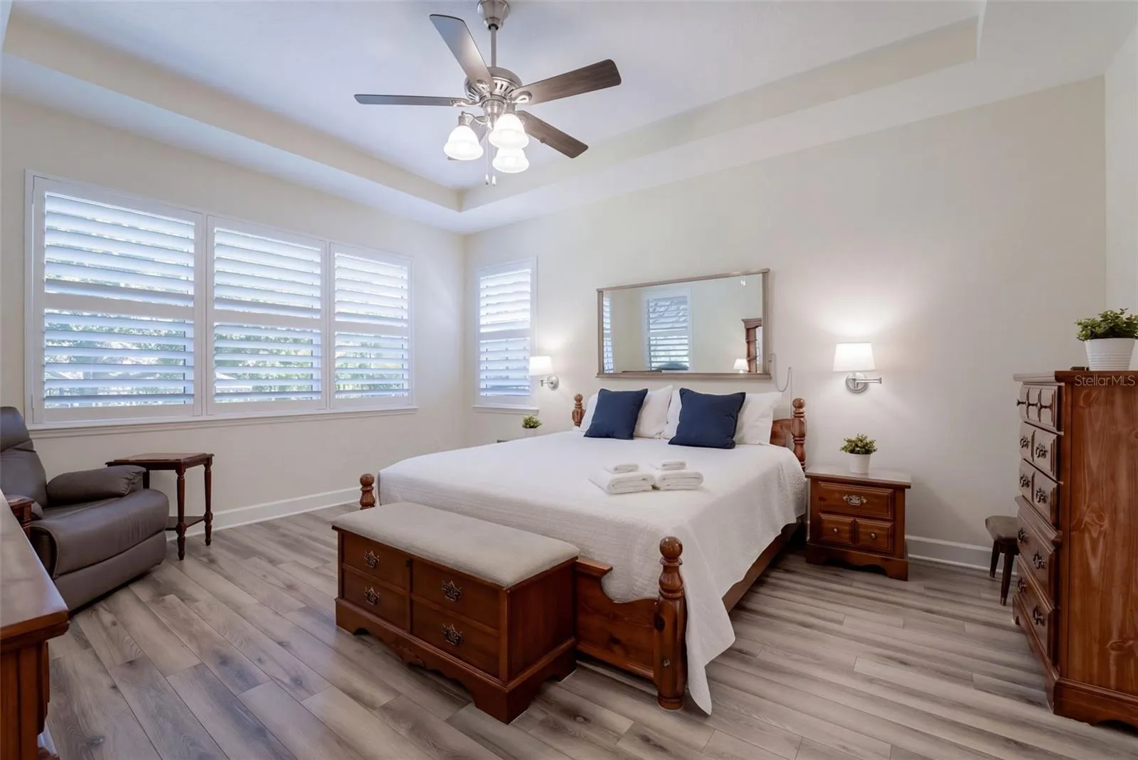 14' x 17' Primary Bedroom w/ a luxury vinyl floor, tray ceiling &amp; a ceiling fan