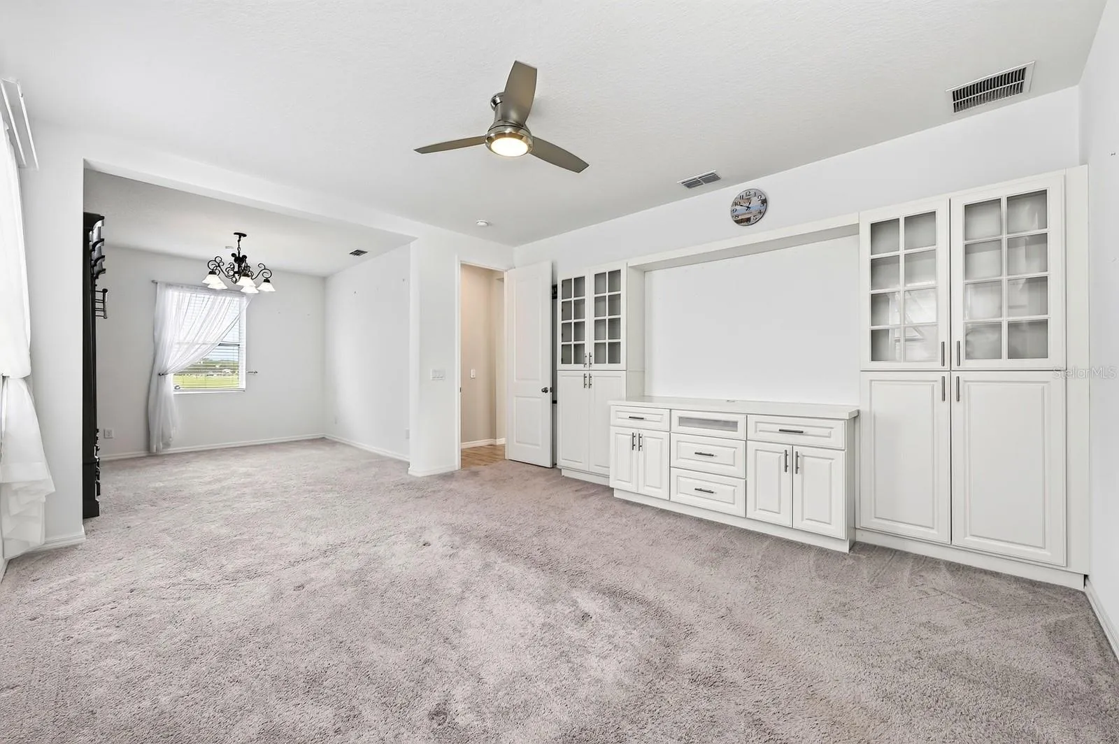 The primary suite has carpet and a ceiling fan