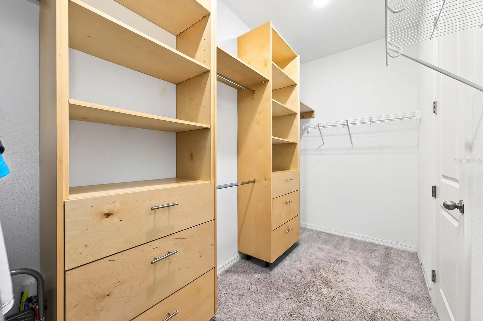 The primary bathroom has this large walk-in closet with BUILT-IN storage for all of your shopping excursions