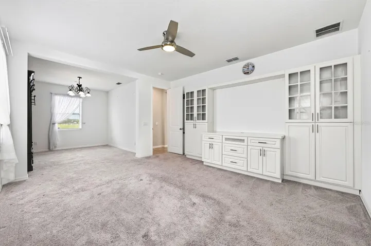 The primary suite has carpet and a ceiling fan