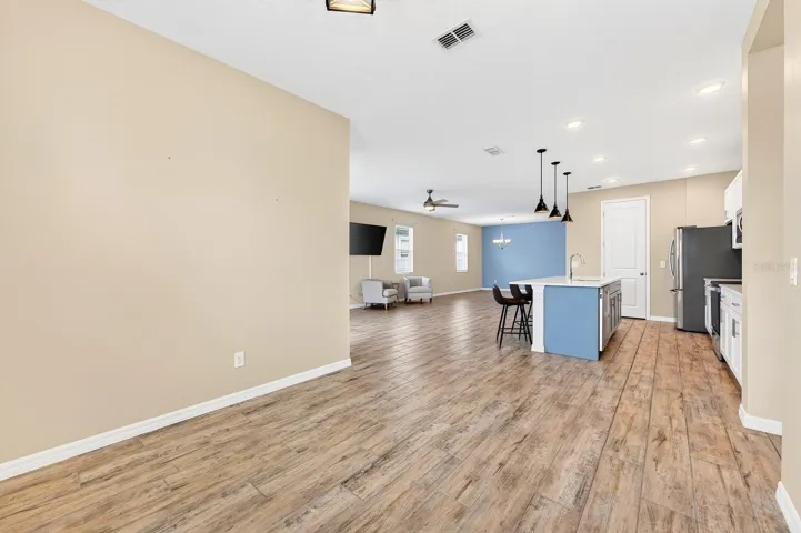This is a look from the breakfast nook across the open-air family space and porcelain wood-looking tile to join the spaces
