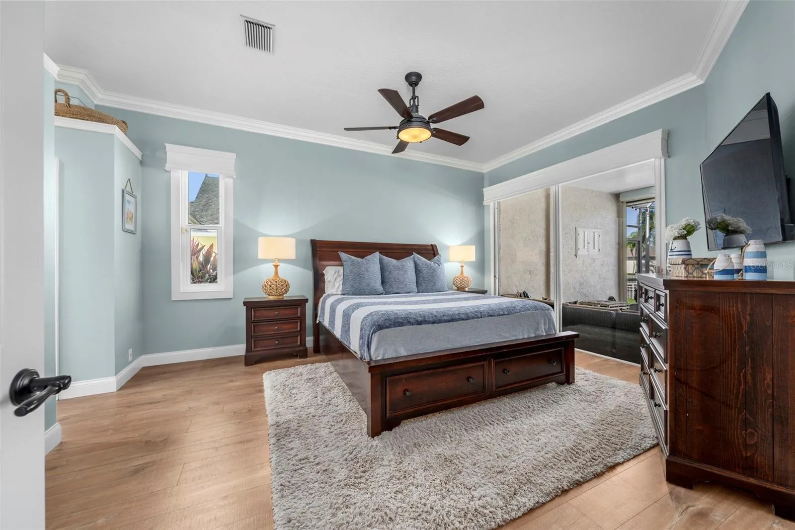 Soft coastal tones and generous natural light create a restful primary retreat with direct access to the lanai.