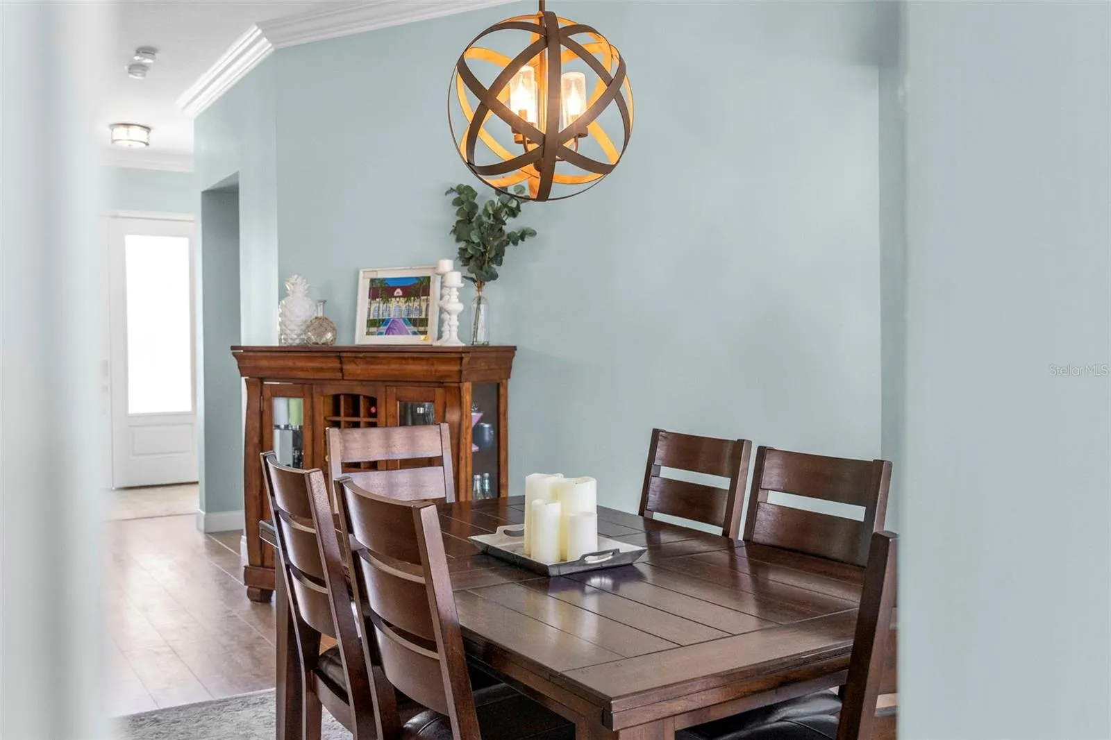 Soft coastal tones and a sculptural light fixture make this an inviting place to gather around the table.