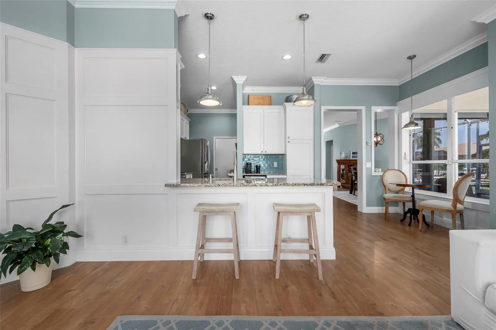 A granite breakfast bar offers a casual place to sit, chat, and keep the cook company.