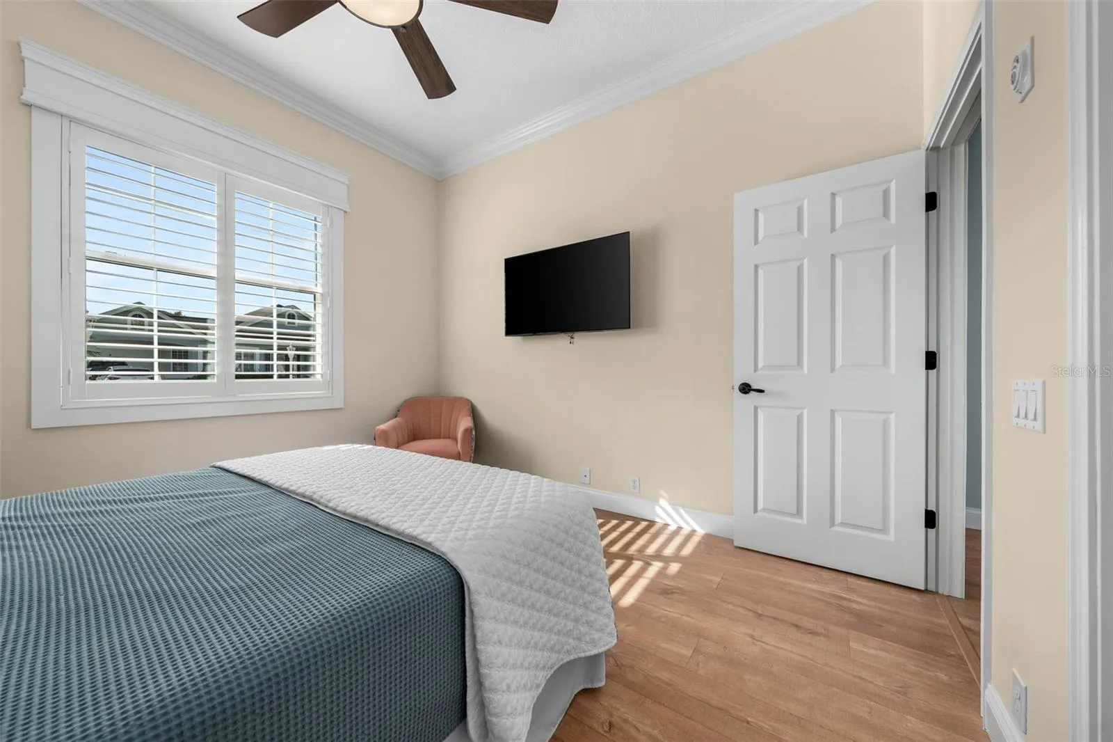 Soft neutral colors, crown molding, and warm flooring make this bedroom easy to personalize.