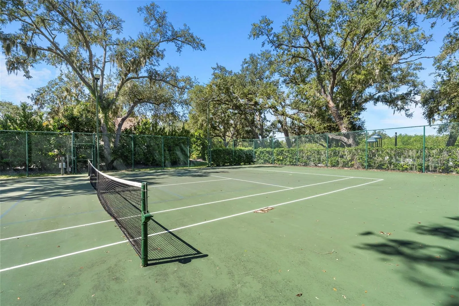 Enjoy a friendly match on the community tennis court, surrounded by mature trees and greenery.