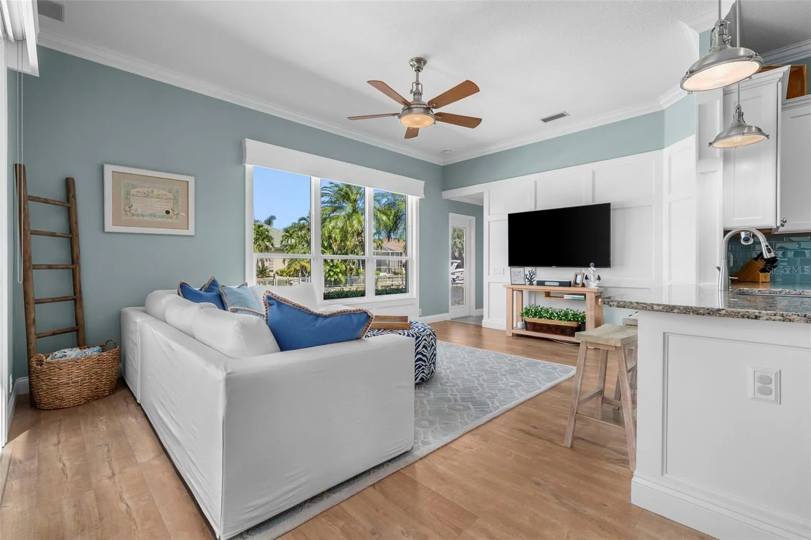 Natural light, waterfront views, and a board-and-batten accent wall bring relaxed coastal style to the living room.