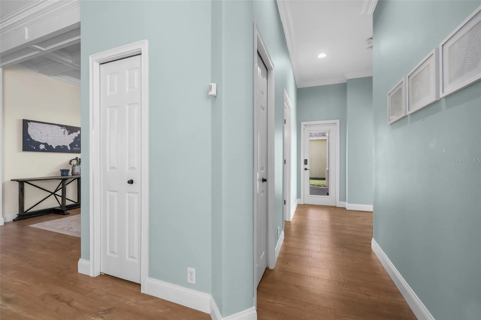 Consistent coastal colors, crown molding, and warm flooring create a cohesive feel from room to room.