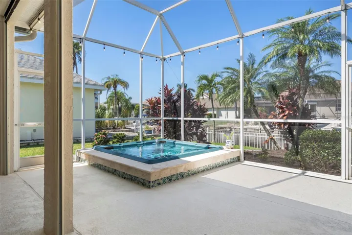 Enjoy a relaxing soak beneath the open sky, with a screened enclosure and tropical surroundings.