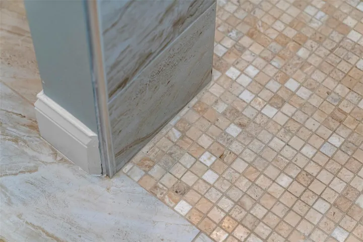 Coordinating mosaic and large-format tile showcase the attention to detail carried throughout the renovation.