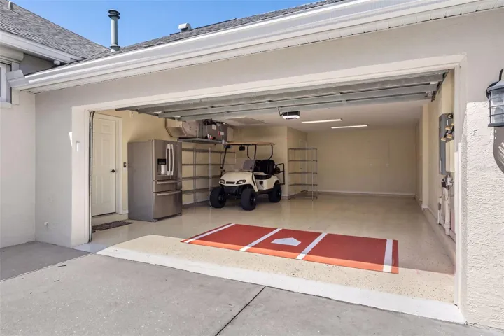The spacious tandem garage features finished flooring and room for vehicles, a golf cart, storage, and boating essentials.