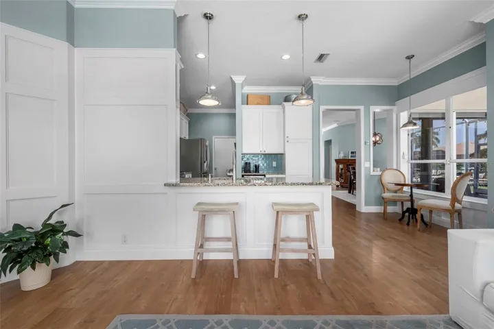 A granite breakfast bar offers a casual place to sit, chat, and keep the cook company.