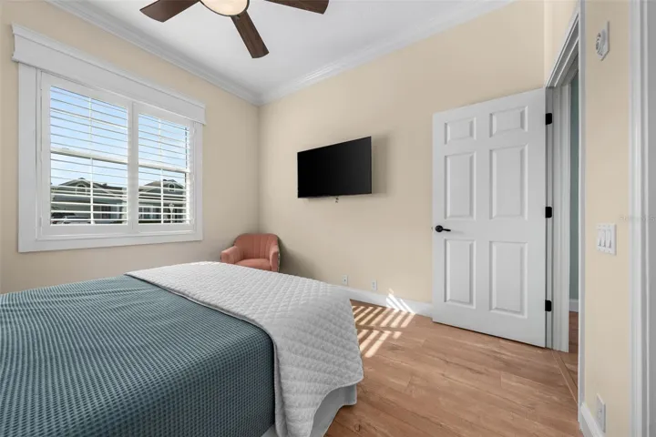 Soft neutral colors, crown molding, and warm flooring make this bedroom easy to personalize.