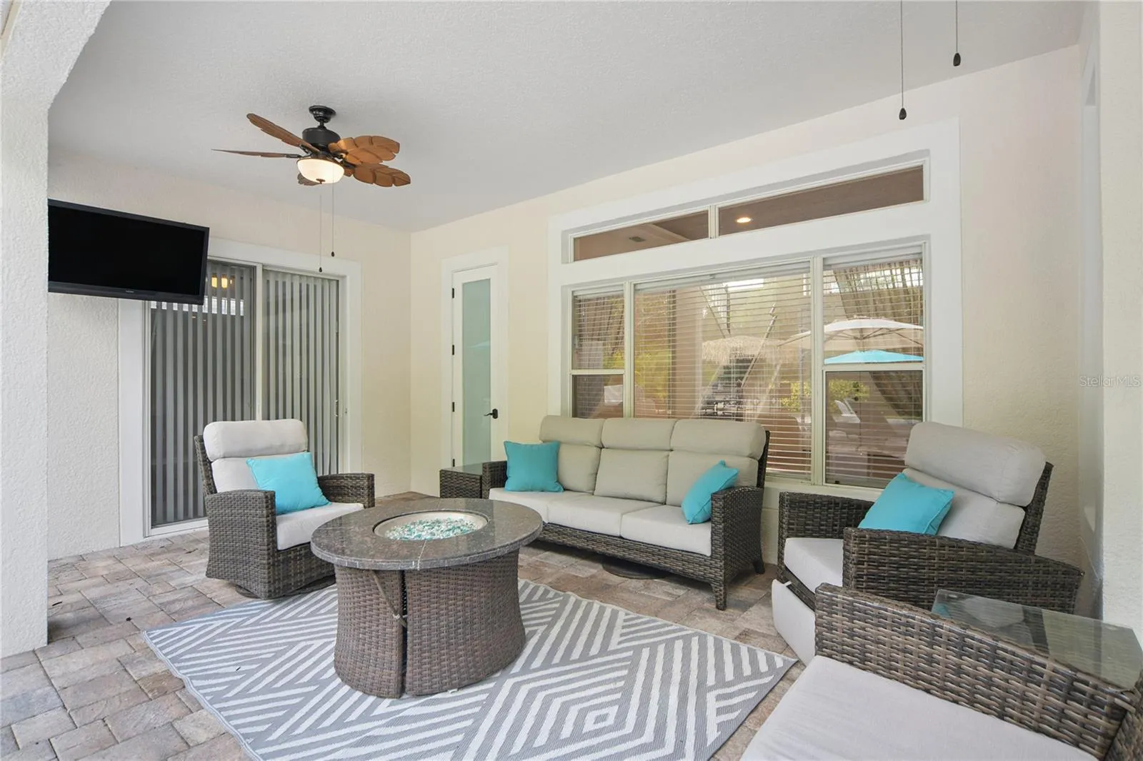 Right outside the family room sliding door is this spacious lanai where you can spend rainy days under cover, take a break from the bright sunshine, or enjoy winter nights by the fire. There are 2 new ceiling fans here, the TV stays and the furniture is negotiable.