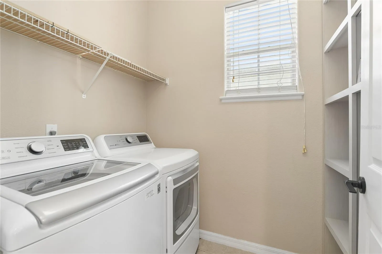 The laundry room that's right off the kitchen with a shelving unit to hold all your supplies.