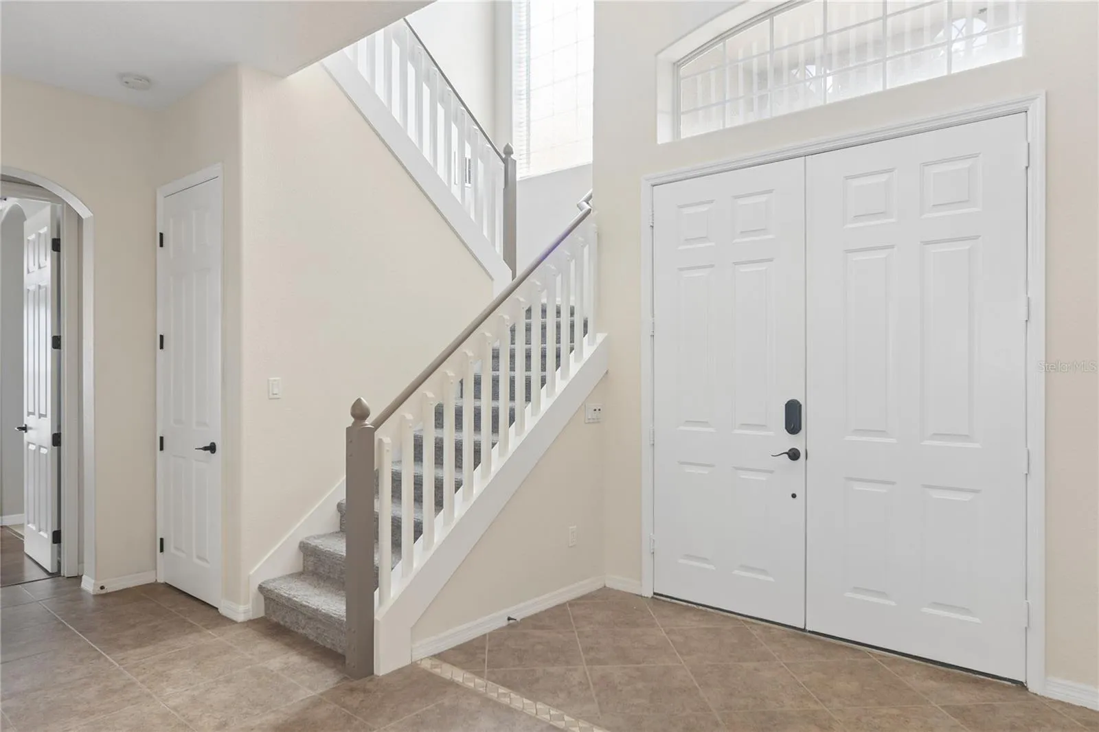 Going thru the double doors into a 2 story foyer and the grand staircase.