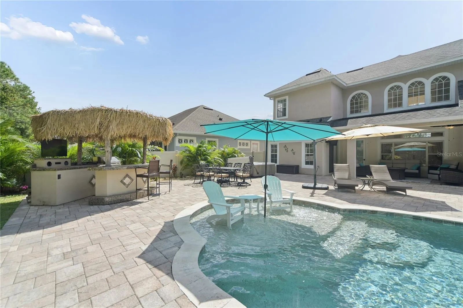 This is the sun shelf with an umbrella receptacle, it's 9 ft wide with enough room for chairs and others to enjoy the shallow water to cool off. Right behind is the outdoor kitchen/tiki bar with a grill, tv, bar fridge, and some storage space.