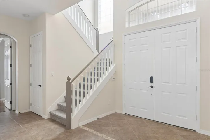 Going thru the double doors into a 2 story foyer and the grand staircase.