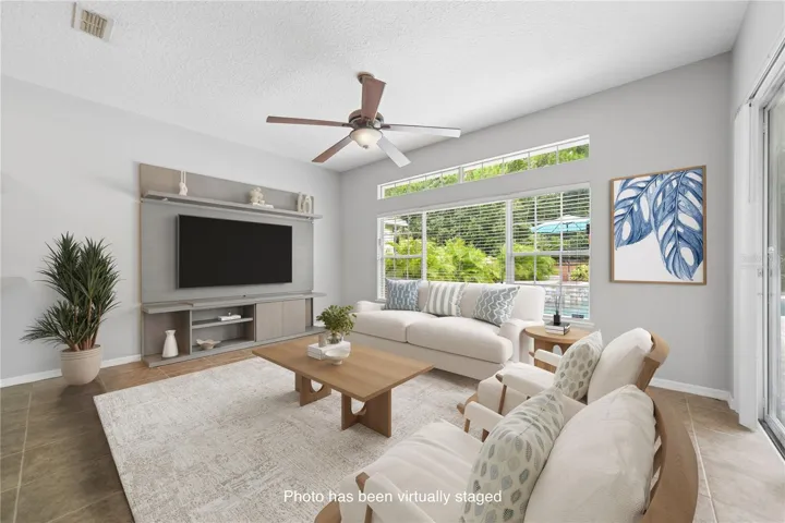 On the other side of the breakfast bar is this spacious family room that over looks the pool in the back yard (photo virtually staged).