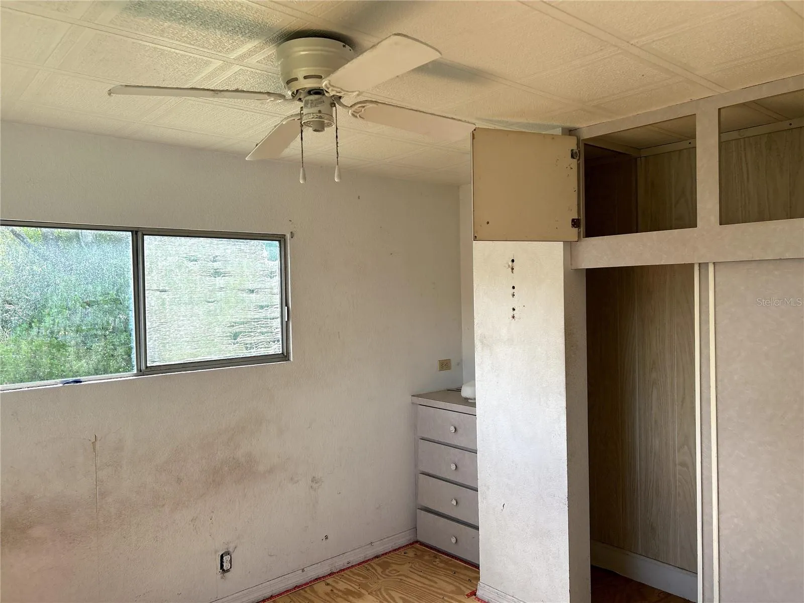 primary bedroom with built in closet and drawers at back of home.