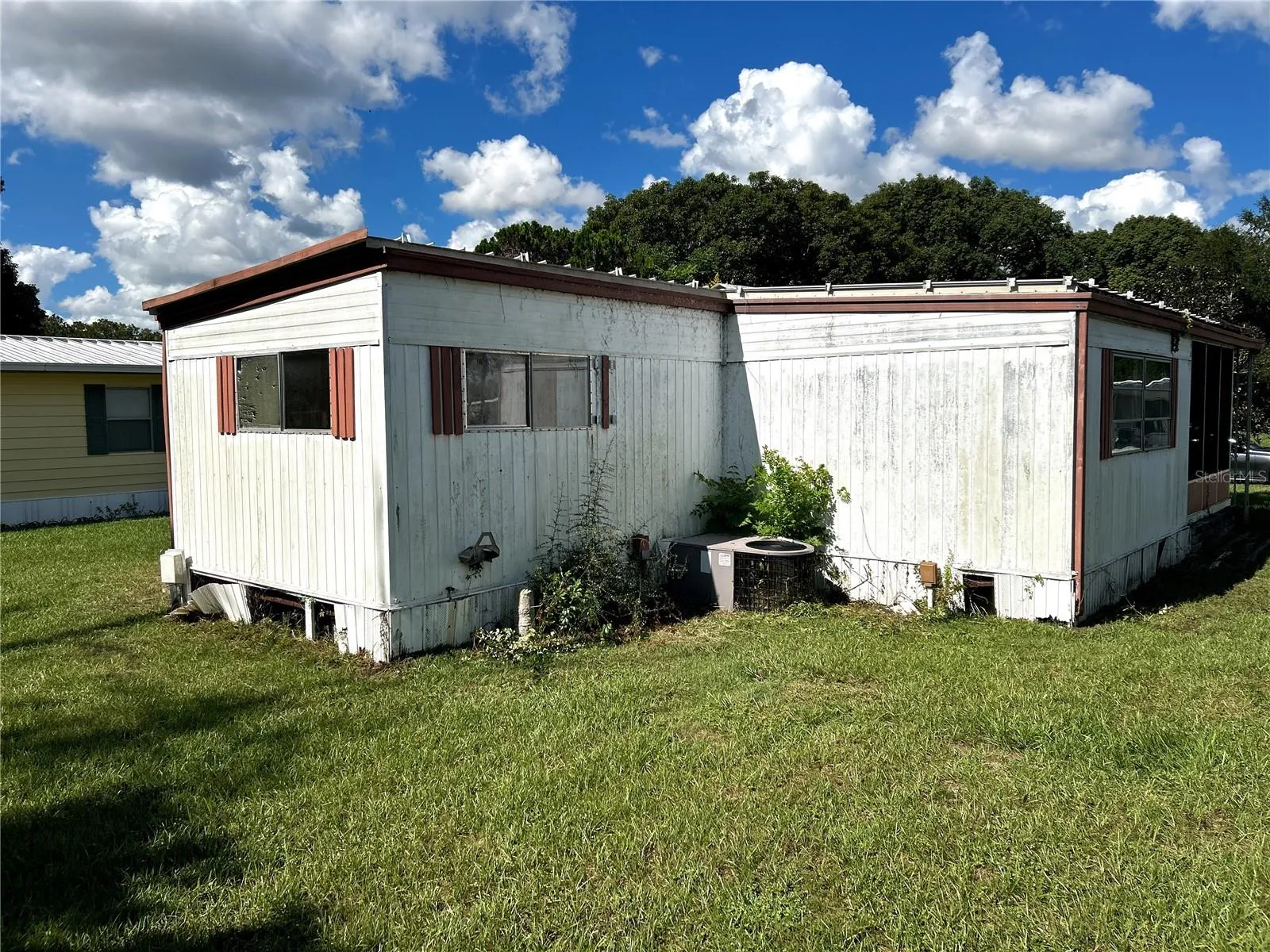 other view of back of home facing primary bedroom, AC unit and living room.