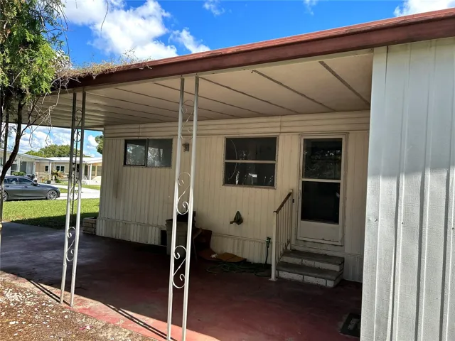 side view looking into carport and utility room/ laundry room with door to kitchen.