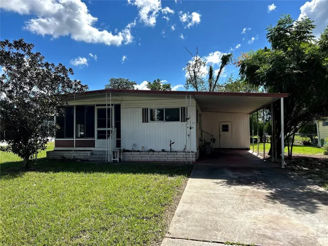 Investor Special! CASH Only. Front view, paved drive, carport, screened porch.