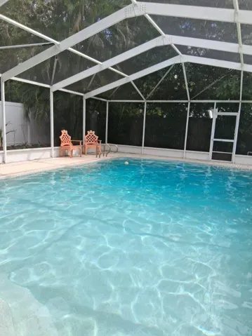Stairs at the shallow end of the pool for entry/exit, and a ladder at the deep end; screen door goes to pool pump area